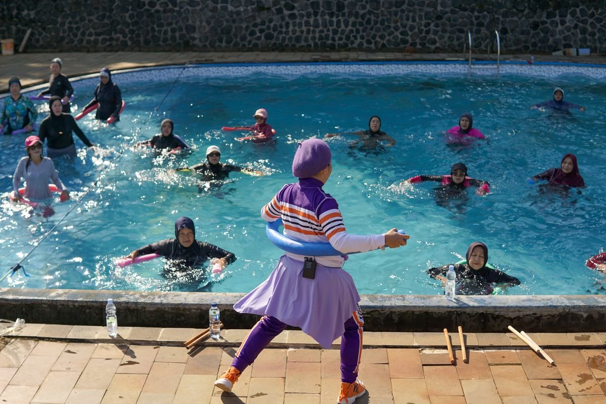 Women participating in a water aerobics class under the sun